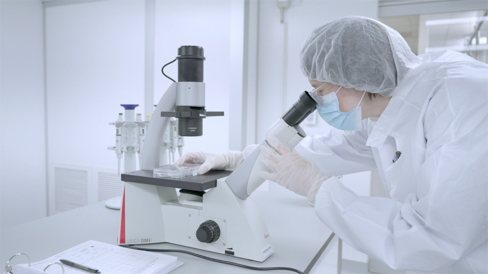 Acorn Biolabs scientist examining cells under a microscope in the lab